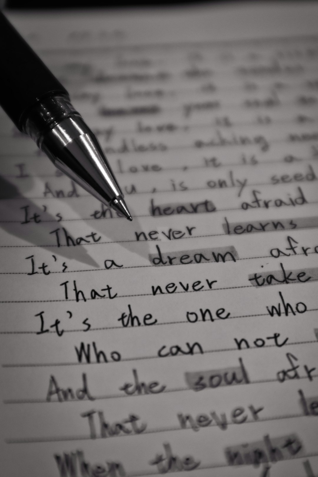 A pen on top of a piece of paper. Words like dream, soul and heart are visible.